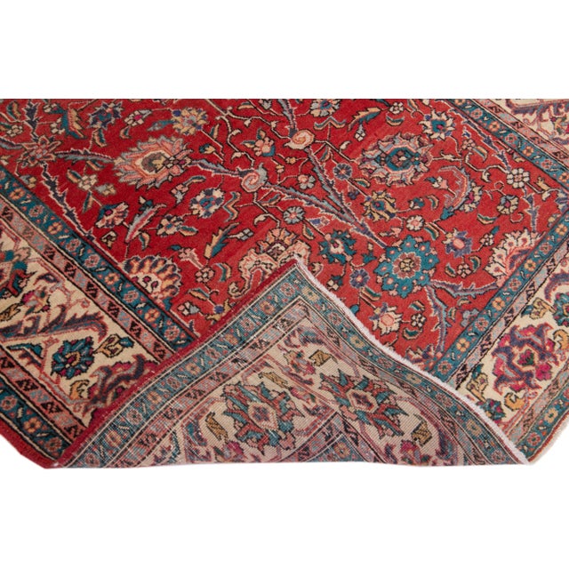 Beautiful vintage Persian Tabriz hand-knotted wool runner with a red color field. This rug has a beige frame and...