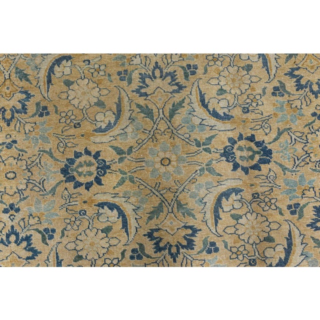 An early 20th century Persian Tabriz rug, the caramel field with an overall herati pattern in dark blue and sand within a...