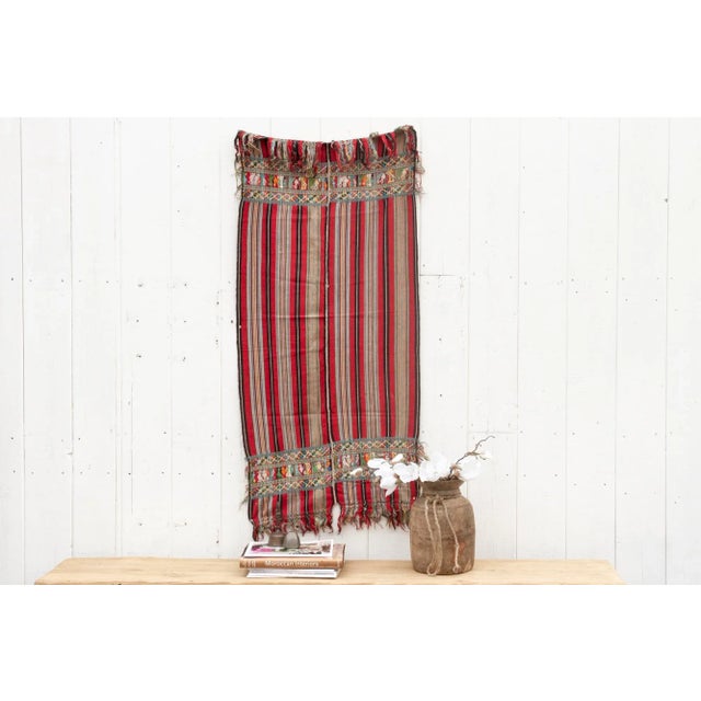 This vibrant vintage huipil unfolds a story woven in threads. Hand-crafted on a back-strap loom, the huipil boasts two red...