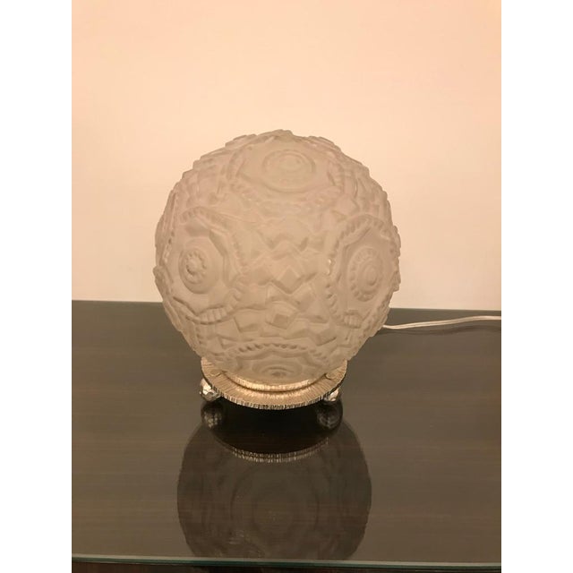 Gorgeous Art Deco table lamp with geometric motif by Sabino. Having a clear frosted geometric glass round shade. Resting...