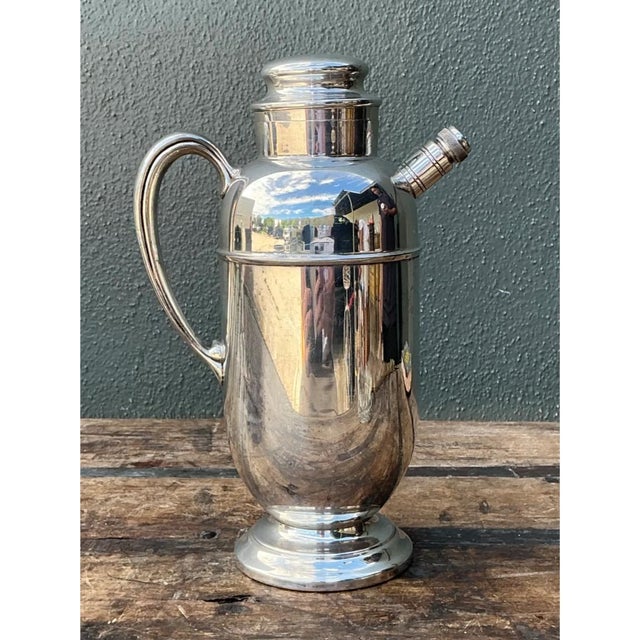 This vintage Art Deco cocktail pitcher exemplifies the sleek, streamlined elegance characteristic of the period's...