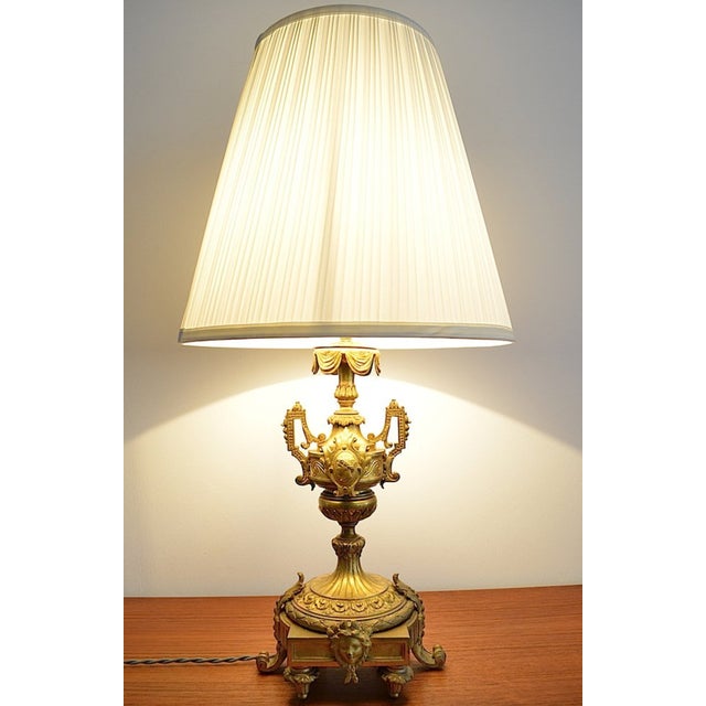 Beautiful table lamp in the Empire or Louis XVI style, circa 1890-1920. The lamp is likely made of gilded bronze. The...