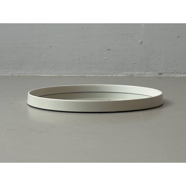 Round wall mirror in the clean, minimalist Space Age style of the 1970s, featuring a design typical of the era. The wide,...