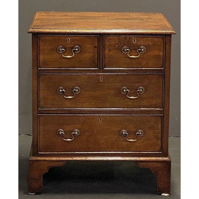 A fine English small chest of patinated oak from the 19th century, featuring a moulded top over a frieze of two beaded...