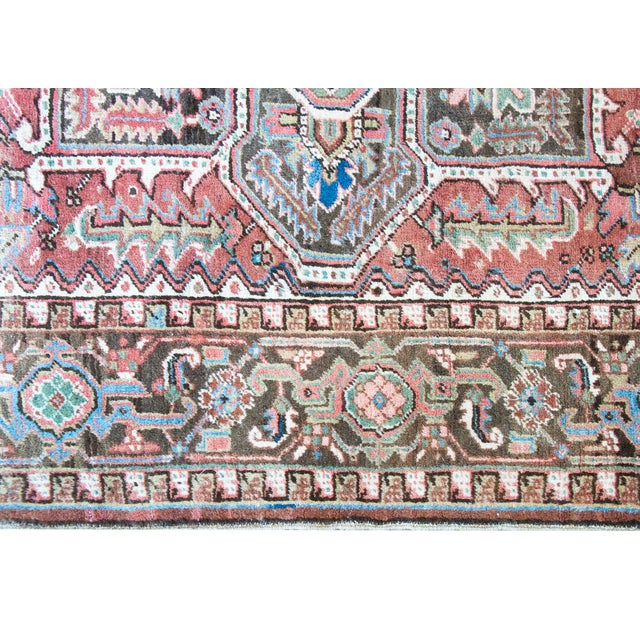 This antique Persian Heriz rug, dating to the late 1940s, features a bold geometric medallion design characteristic of the...