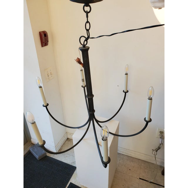 6 Light Iron Chandelier in Iron Oxide finish with whit metal candle covers. This Chandelier is suitable for a transitional...