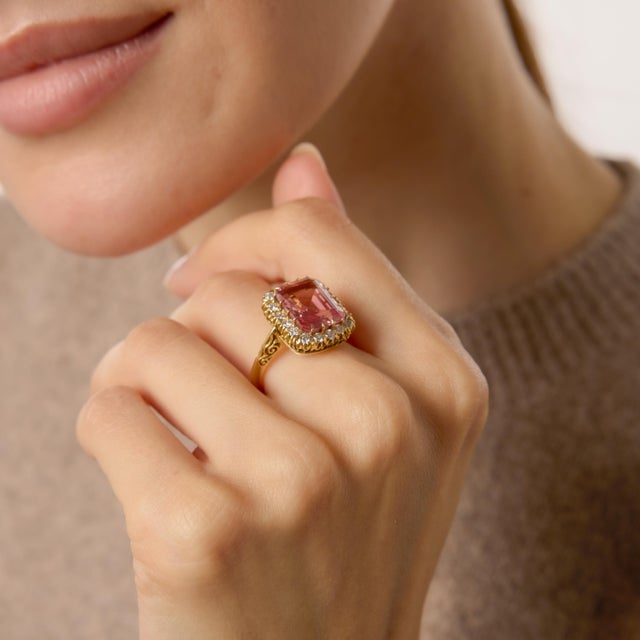 A bold and radiant statement from the 1970s, this vintage ring centers on a magnificent 6.00 carat rectangular emerald cut...