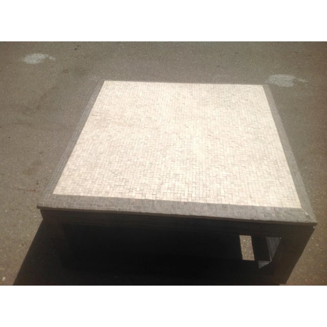 Designer coffee table with unique top. Top is shell stone and sits on top of base. Top is not heavy. Base is wood and...