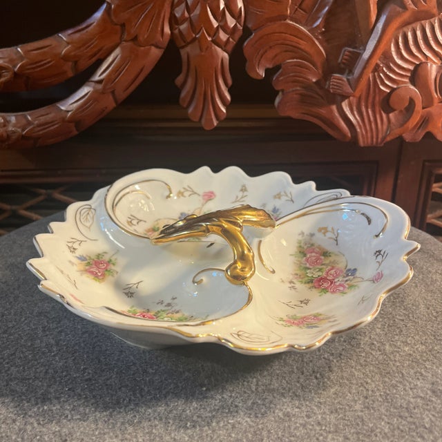 White with hand painted floral motif, gold trim & handle. Numbered on underside 55/1127.