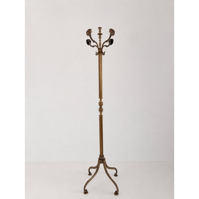 Elegant vintage brass coat rack featuring distinctive shield-shaped hooks, a beautifully twisted column, and a decorative...