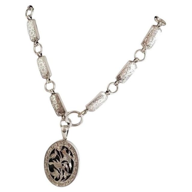A fine Victorian sterling silver oval locket and original chain, dating to circa 1880 and displaying the distinctive...