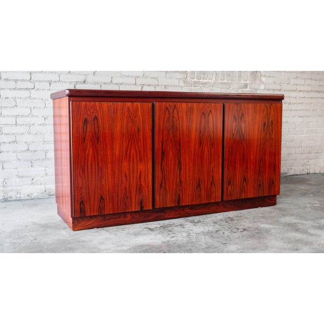 Beautiful Rosewood credenza or sideboard by Rasmus, circa 1970s. Three doors open to ample storage space with one side...