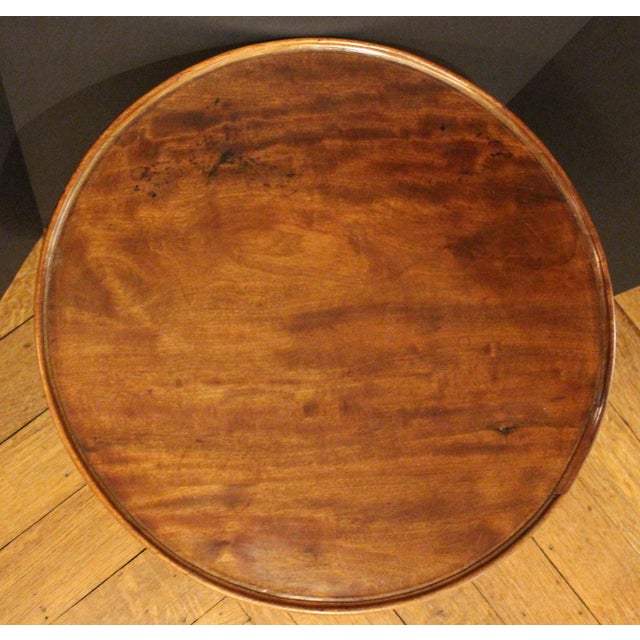 Circa 1750, George II period small tilt-top tea table, English. Dish-top over gun barrel shaft with ring turning to shaped...