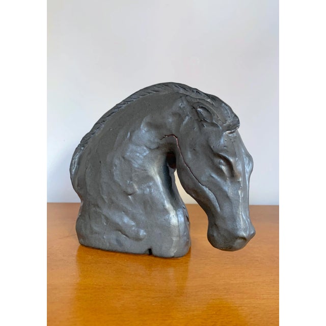 Horse Head in Black, is a depiction of the beauty and grace of a horse. Stoneware ceramic with a black glaze. Minor crack...