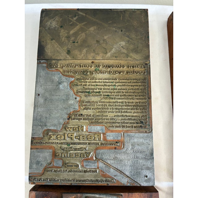 A set of four authentic antique letterpress printer’s blocks featuring original reversed advertising plates mounted to...