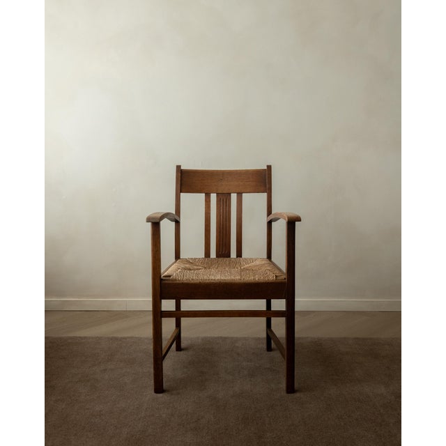 An antique dutch art deco armchair in oak and woven rush, made by an unknown dutch maker and likely produced in the...
