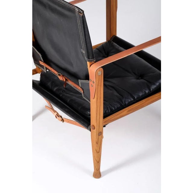 Pair of Kaare Klint "Safari chair" in patinated black leather with original seat cushions. Designed by Kaare Klint in...