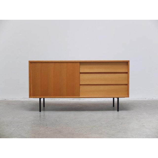 Beautiful compact sideboard designed by Helmut Magg for Deutsche Werkstätten around 1960. Made of a lighter ash wood with...