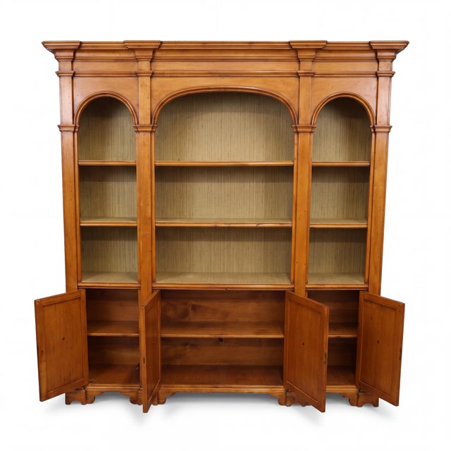 This is a 1970s Italian neoclassical style carved fruitwood library bookcase or cabinet. It breaks down into three parts...