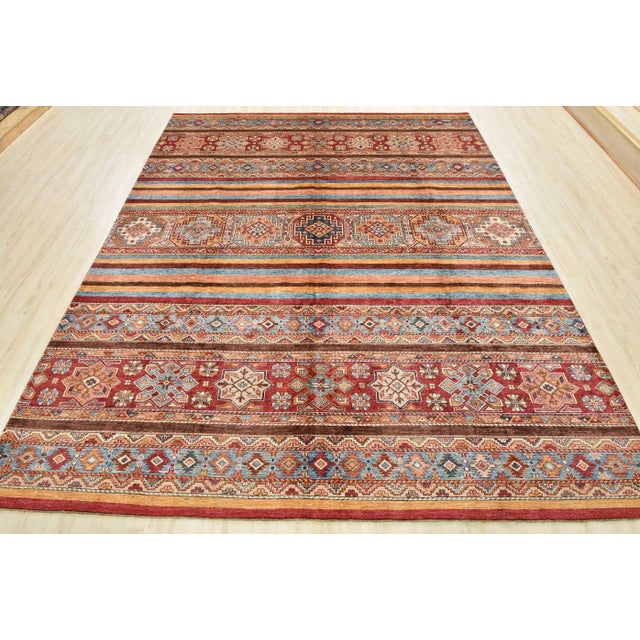 A tribal Khorjin rug hand-knotted with an all-wool pile on a cotton foundation. This finely woven oriental rug features...