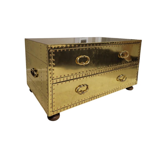 Striking Campaign Revival trunk table or low chest clad entirely in sheet brass and secured with a dense grid of...