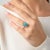 This enchanting Victorian cluster ring showcases a vibrant cabochon turquoise, glowing with a rich, sky-blue hue that...