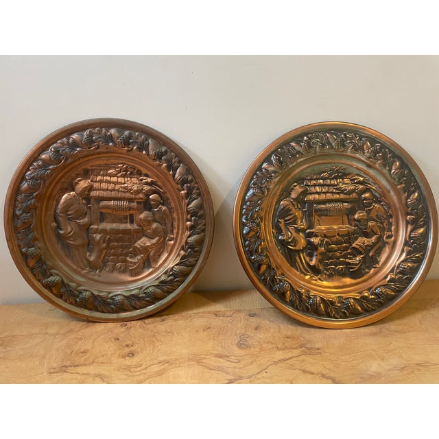 A charming matching pair of vintage embossed copper decorative wall plaques. Each heavy-gauge metal charger features a...