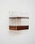 Modular mahogany wall shelf with a white lacquered metal frame and integrated drawer. Original labels present. Designed by...