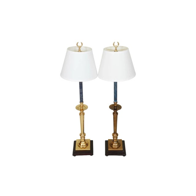 A pair of traditional style table lamps made by Ethan Allen. White lamp shades are secured with brass wreath finials above...