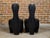 A sculptural pair of Midcentury African wood spoon back black chairs with carved reeded bases. This sculptural pair of...