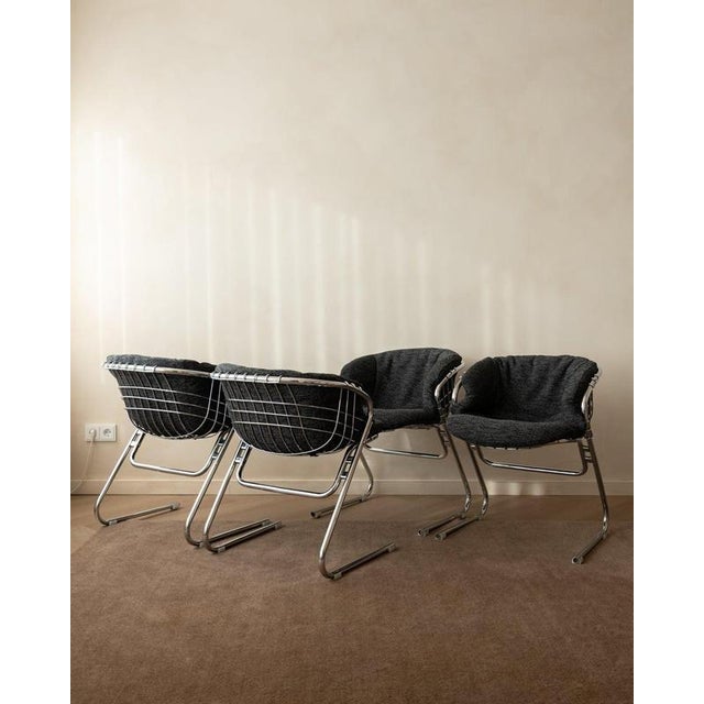 A vintage set of four italian flynn dining chairs in chrome-plated steel with original dark charcoal textile upholstery,...