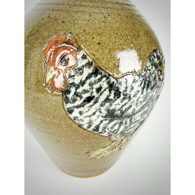 This handmade stoneware jug is a signed studio pottery piece by Katie Lisk and C. Lisk, featuring a boldly hand-painted...