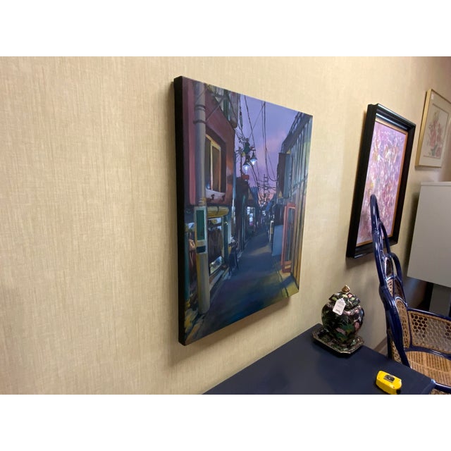 Lovely cityscape of a side street in the evening, really beautiful depiction. Artist initials on side of painting NG.