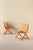 A beautiful pair of foldable lounge chairs in warm-toned wood with woven seats and backs. The curved, ergonomic shape...