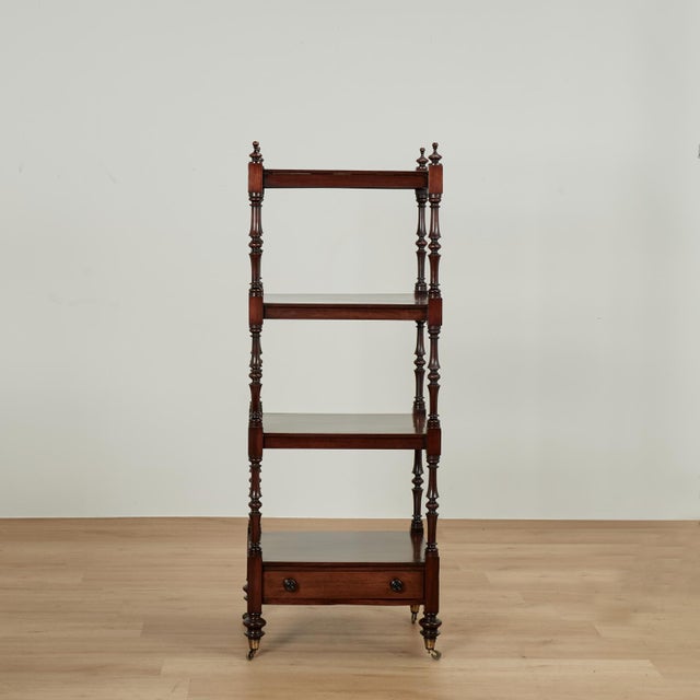 Handsome 19th century English etagere handcrafted in mahogany with four tiers on classic tuned supports with finials at...