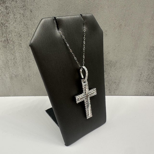 This striking diamond cross pendant necklace in 14kt white gold features 1.20 carats total weight of natural GH SI2–I1...