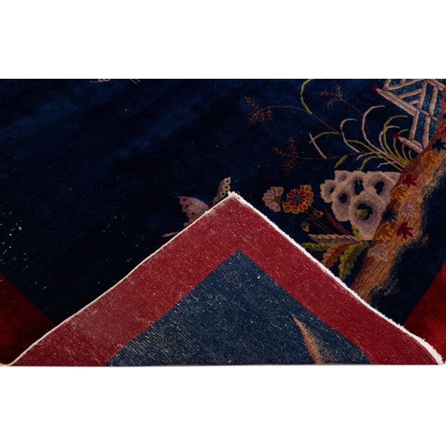 Beautiful antique Art Deco Chinese hand-knotted wool rug with a blue field. This Chinese rug has a red frame and multi-...