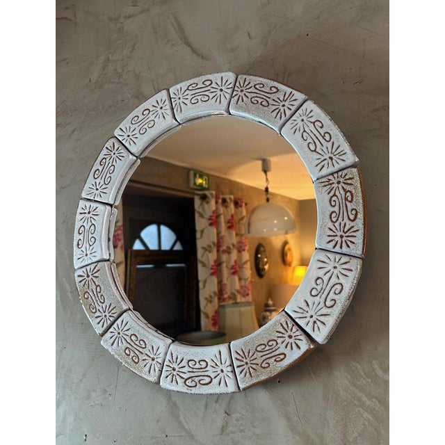 Pretty round mirror surrounded by pieces of beige ceramic and brown decor dating from the 60s, probably made in Vallauris....