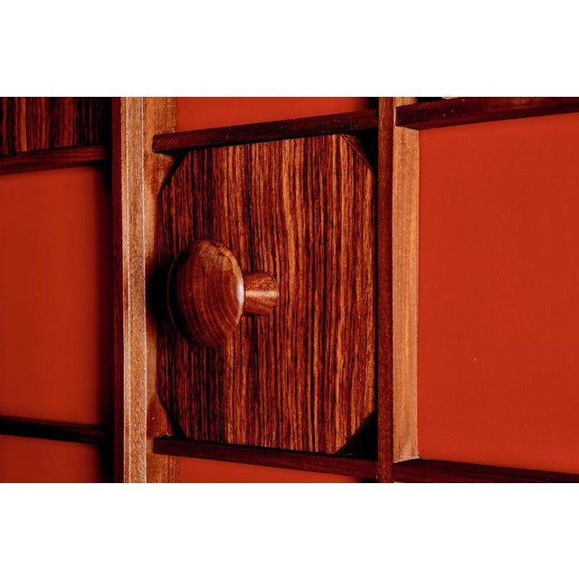 Mid-Century Modern wardrobe or wall unit, crafted in the 1960s. This striking piece features a bold red background framed...