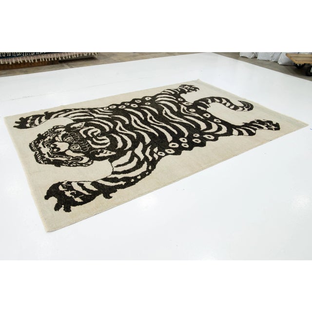This Turkish Art Deco wool rug boasts a striking beige backdrop with bold black accents and a captivating pictorial...