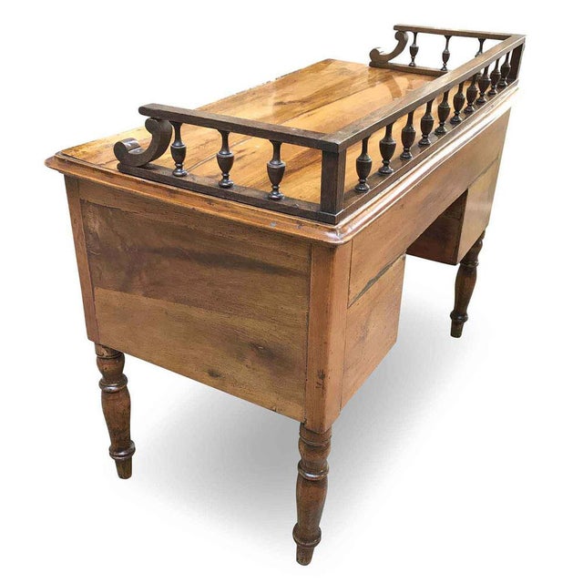 Antique walnut centerpiece desk from the mid-1800s in good condition. It features a large rectangular top bordered by a...