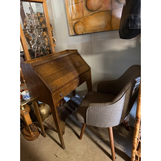 antique Arts & Crafts/Mission-style oak drop-front secretary, circa 1900–1925. It features tiger-grain oak, interior...