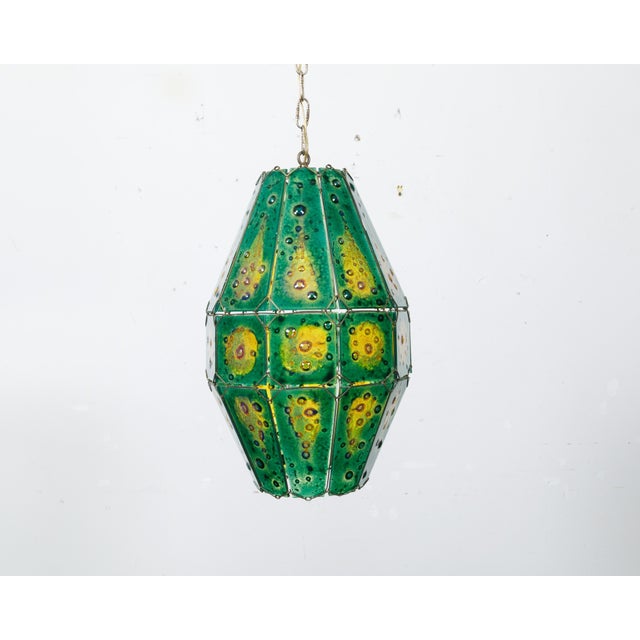 A Felipe Derflingher art glass pendant light fixture from circa 1970 with green and yellow tones. Crafted by the esteemed...