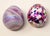 Offering a unique pair of art glass eggs. One is white with blue, green and pink dots, and the other is iridescent in...