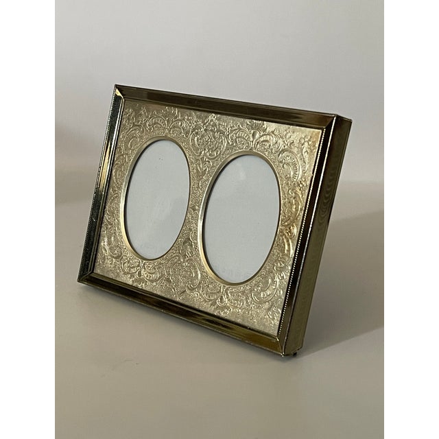 A beautiful picture frame decorated with an intricate pattern of scrollwork elegantly encircling a pair of double oval...