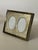 A beautiful picture frame decorated with an intricate pattern of scrollwork elegantly encircling a pair of double oval...