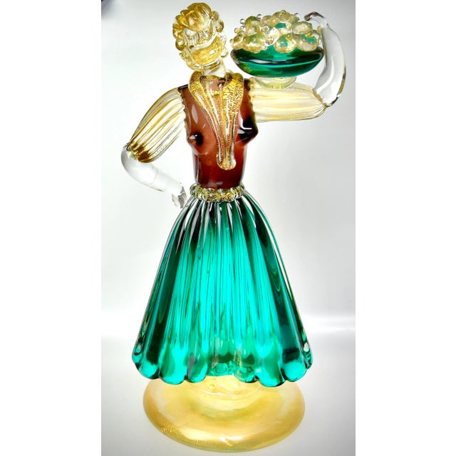 A magnificent pair of mid century Murano art glass figures, depicting a harvest scene of a couple carrying a bowl of...