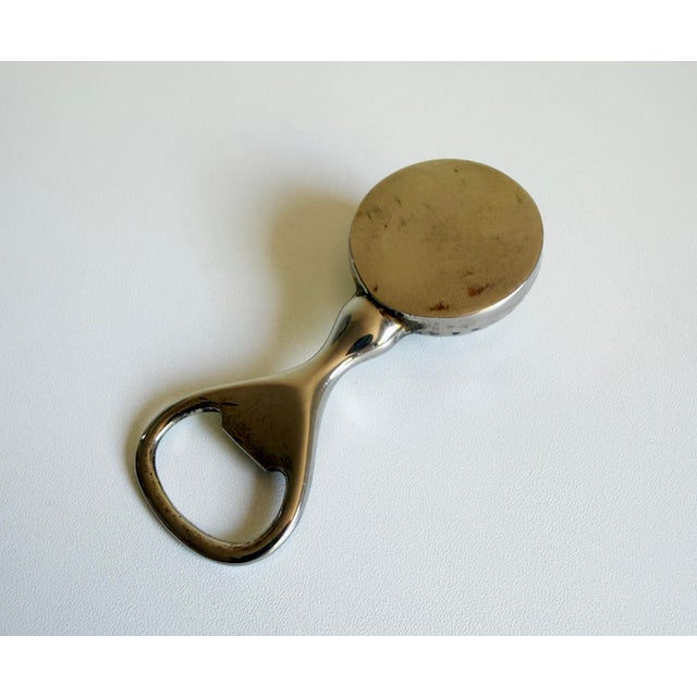 This vintage silver-finish bottle opener from the 1960s features a golf ball-shaped design that combines functionality...