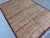 This understated rug features a grid of small squares, each filled with a fine vertical stripe texture in faded rust,...