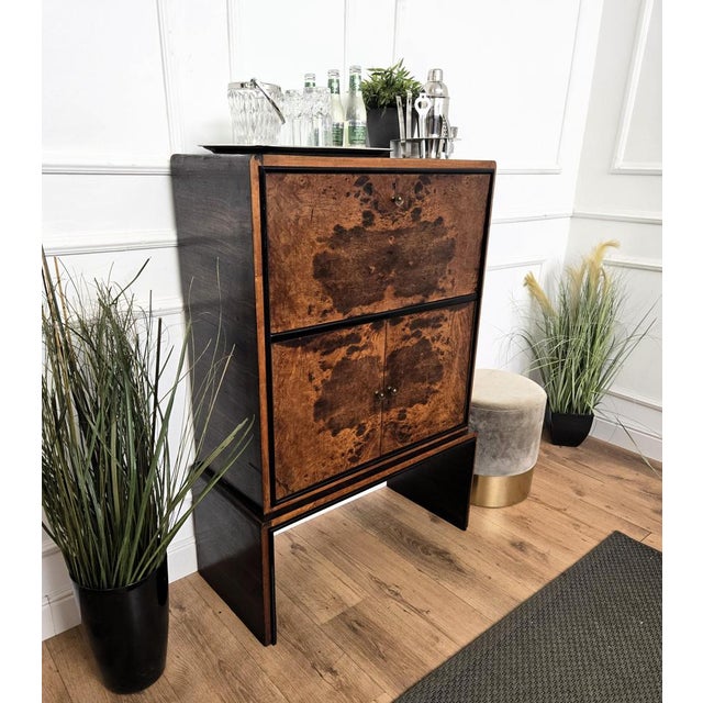 Beautiful 1940s Italian Art Deco bar cabinet in great wood veneer, three front doors, standing on waterfall legs giving...